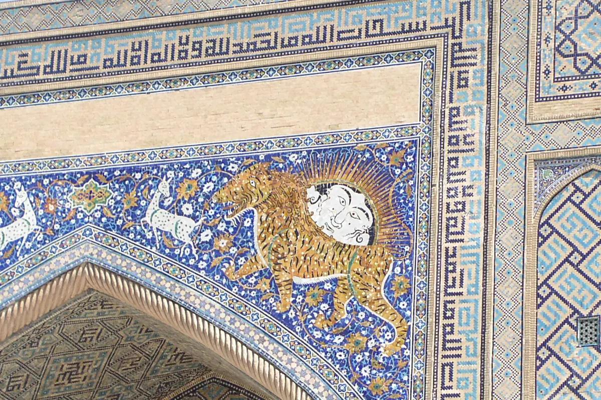Mosaic of a tiger with a rising sun face on its back in blue tile above the portal of the Sherdar Madrasa on Registan Square
